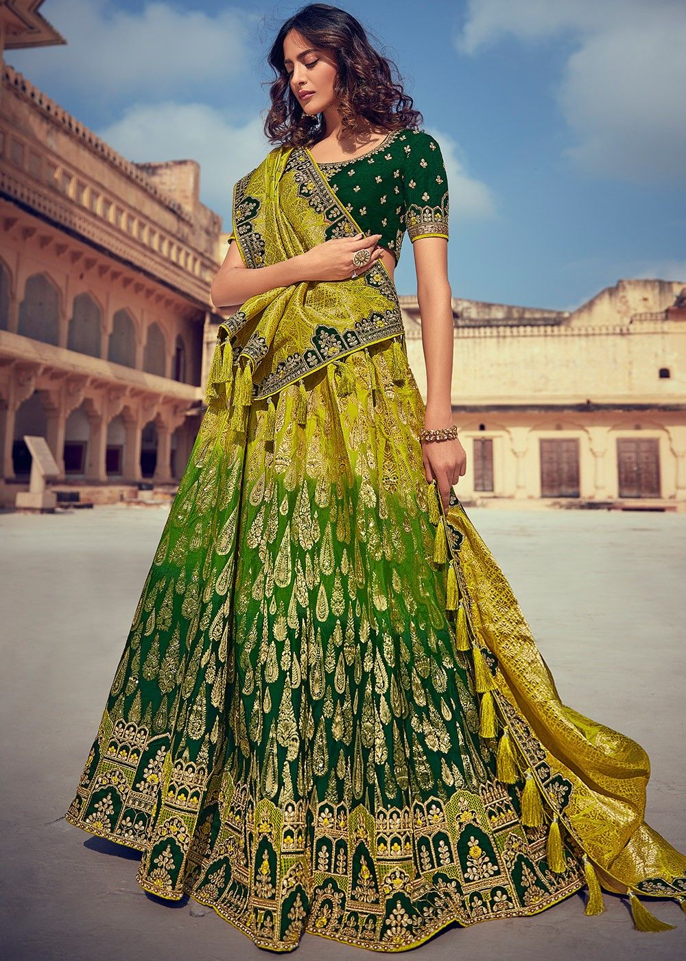 Yellow Lehenga along with Green Dupatta with Jacquard Zari Work the Lehenga  and Beautiful Embroidery Work on Organza Duapatta along with Solid Blouse  having Embroidery and Moti Work.
